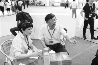 记者在第六届智博会上采访王建宇（右）。.jpg